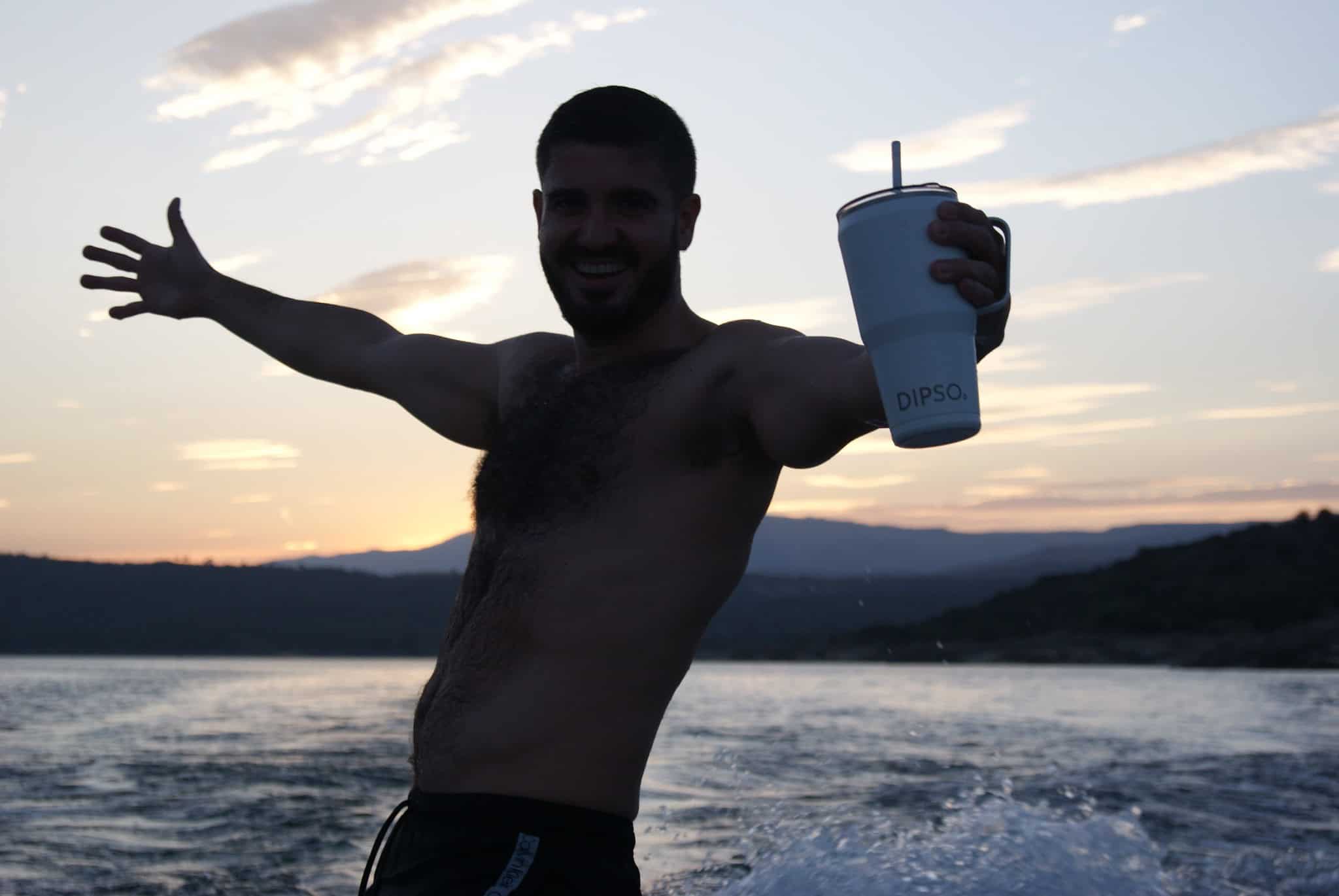 Imagen de un chico realizando deportes acuáticos mientrasporta una taza térmica.
